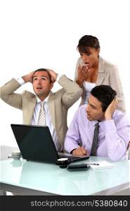 Three shocked business people looking at results