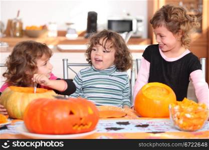 Three sisters carving pumpkins.
