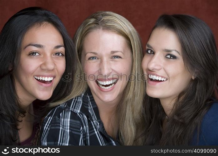 Three smiling young women in a studio setting