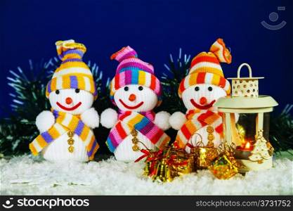 Three snowman with a lantern and presents