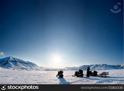 Three snowmobiles on a beautiful winter landscape