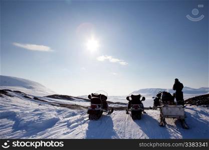 Three snowmobiles on a Svalbard Landscape - winter adventure