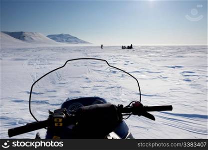 Three snowmobiles on an outdoor winter landscape