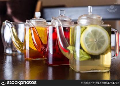 three square teapots with different colors fruit tastes of tea