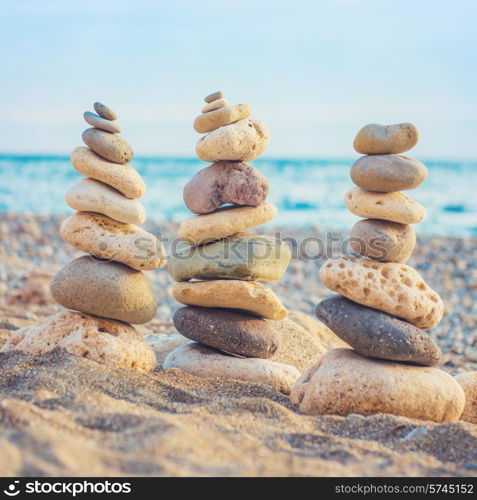 Three stacks of round smooth stones on the beach