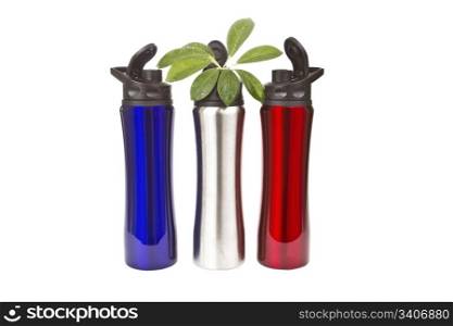 Three stainless steel water bottles in blue,red and silver colors with plant on white background