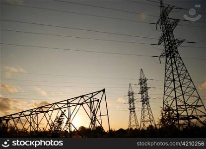 Three standing electrical towers and one fallen