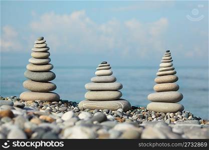three stone stacks on pebble beach, sunlight