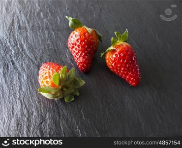 Three strawberries on a slate&#xD;&#xA;