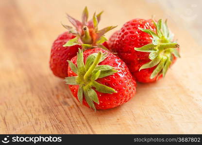 three strawberries on wooden table