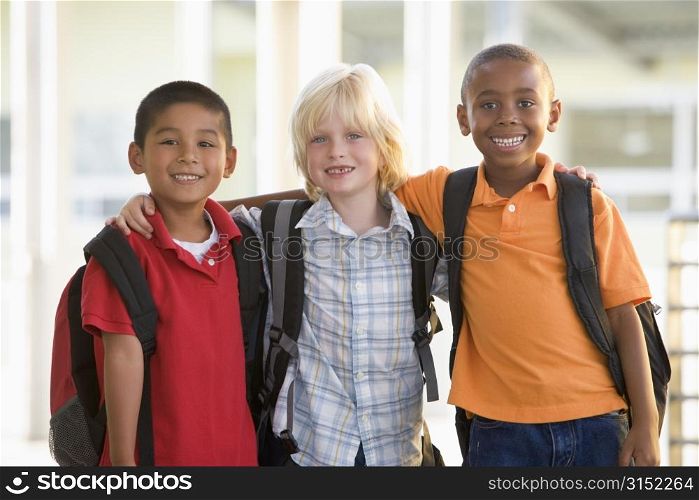 Three students outside school standing together smiling (selective focus)