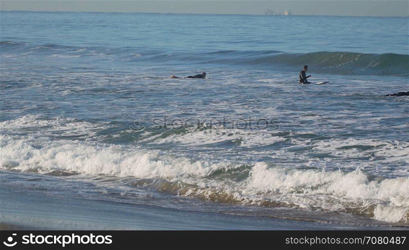 Three surfers near the Santa Monica Pier.