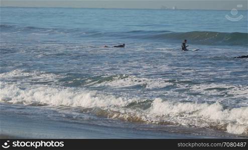 Three surfers near the Santa Monica Pier.