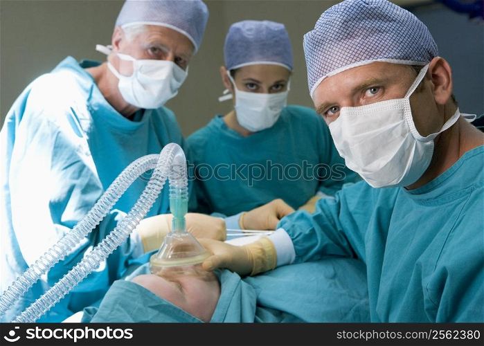 Three Surgeons Operating On A Patient
