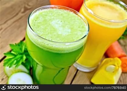 Three tall glass of carrot juice, cucumber, pumpkin on a wooden boards background
