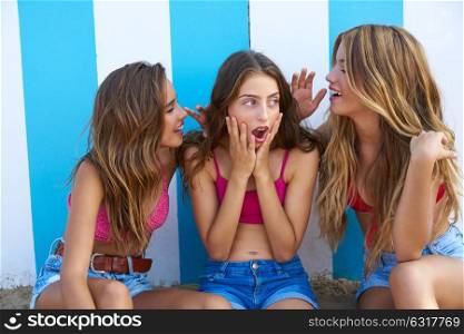 Three teen best friends girls funny whispering gesture in a beach stripes background