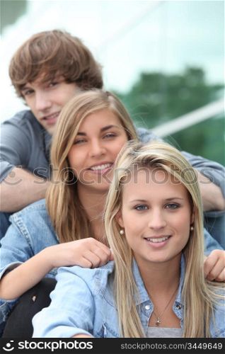 Three teenage friends sat on steps