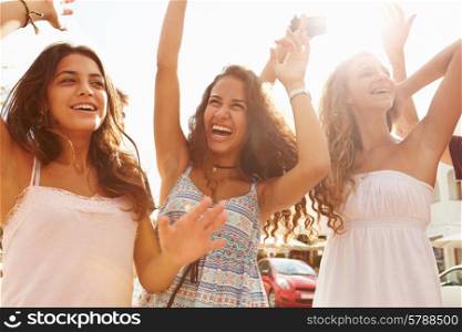 Three Teenage Girls Dancing Outdoors Against Sun