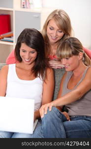 Three teenage girls watching laptop computer
