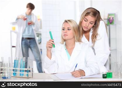 Three teenagers in science class