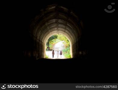 three teenagers on their way through the tunnel light