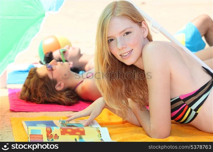 Three teenagers sunbathing together