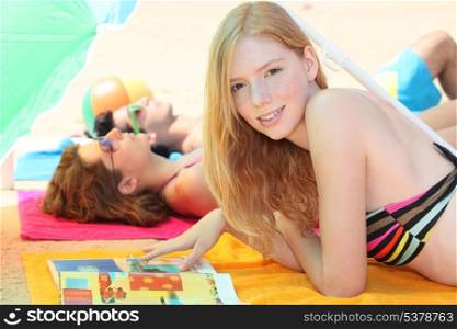 Three teenagers sunbathing together