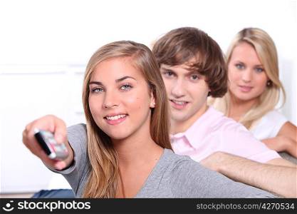 Three teenagers watching television together