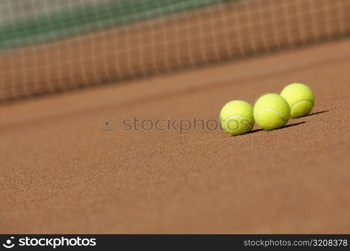 Three tennis balls on a tennis court