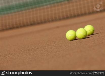 Three tennis balls on a tennis court