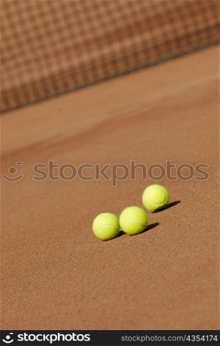 Three tennis balls on a tennis court