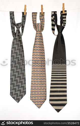 Three Ties Hanging On a Rope With Wooden Pegs.