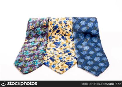 Three ties of different design and color, neatly displayed, one next to the other on a white isolated background.