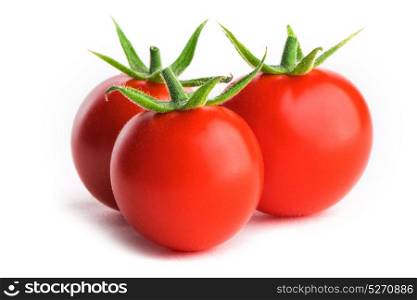 Three tomatoes on white. Three small fresh tomatoes with green leaves isolated on white background