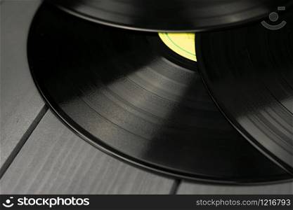 Three traditional glossy black vinyl records without scratches on a gray wooden table