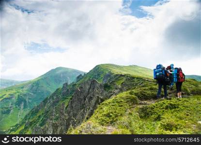Three travelers on the path in Carpathians mountains