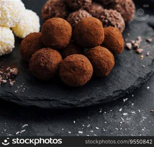 three types of chocolate balls on stone board