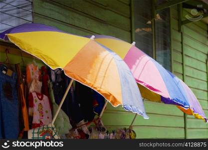 Three umbrellas with clothes in a clothing store, Coxen Hole, Roatan, Bay Islands, Honduras