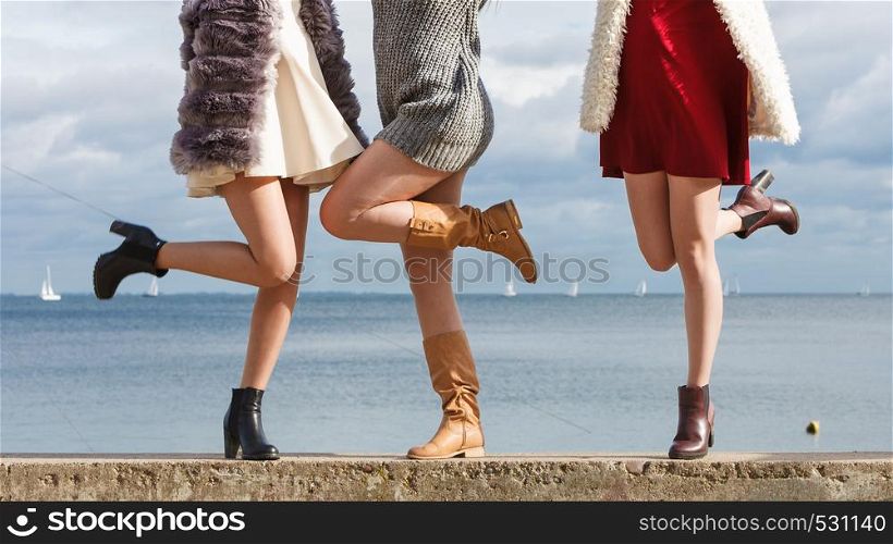 Three unrecognizable fashionable women wearing stylish shoes outdoor. Boots perfect for autumn and winter. Three women presenting shoes outdoor