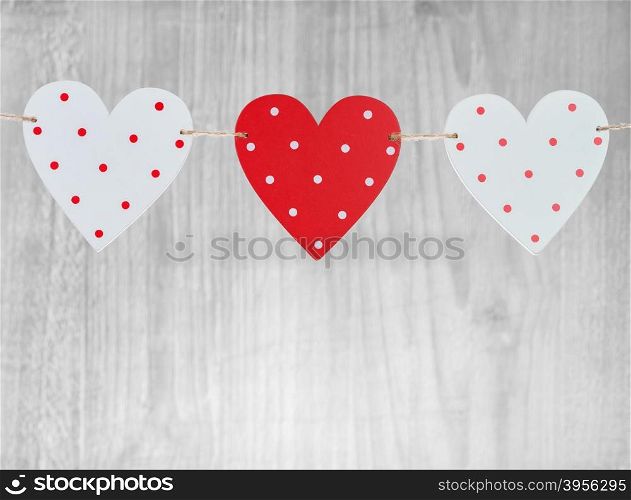 Three Valentines Day hearts on vintage wooden background as Valentines Day symbol