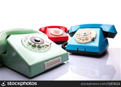 Three vintage telephones isolated over white background