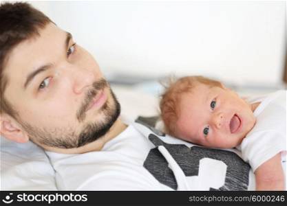 Three weeks old newborn with his father. Shallow depth of field.
