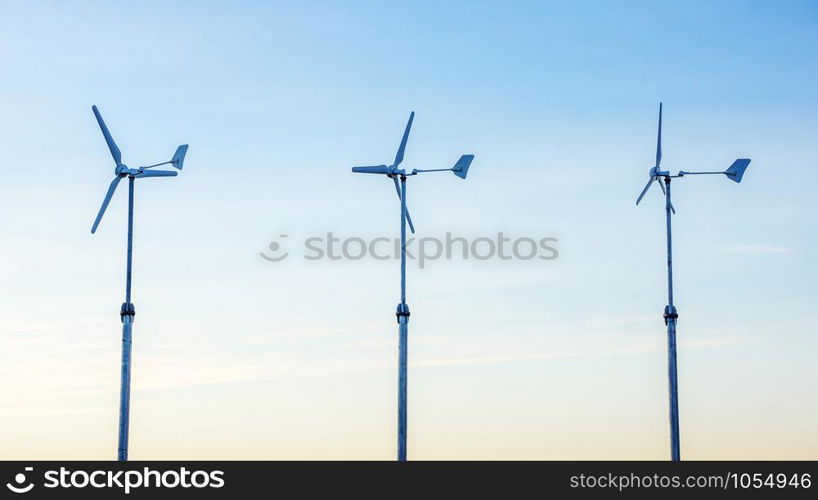 three wind turbine in the sunset.