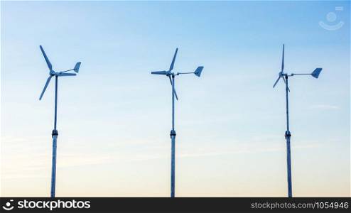 three wind turbine in the sunset.