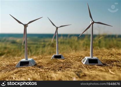 Three wind turbines in the field, nobody. Wind-turbine, alternative eco energy concept, eco electricity generation, renewable resource. Three wind turbines in the field, nobody