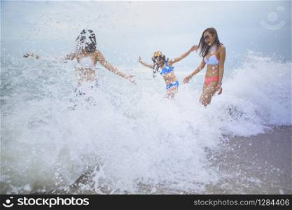 three woman happiness emotion with splashing sea beach wave