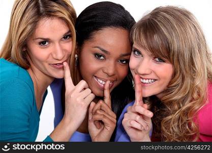 Three woman making shush gesture