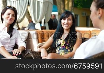 Three women enjoy a coffee break at outdoor cafe