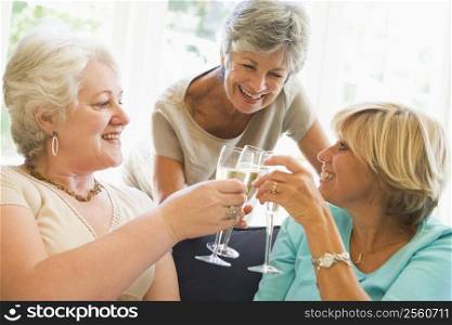 Three women in living room toasting champagne and smiling