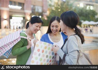 Three Women Looking Into Shopping Bag